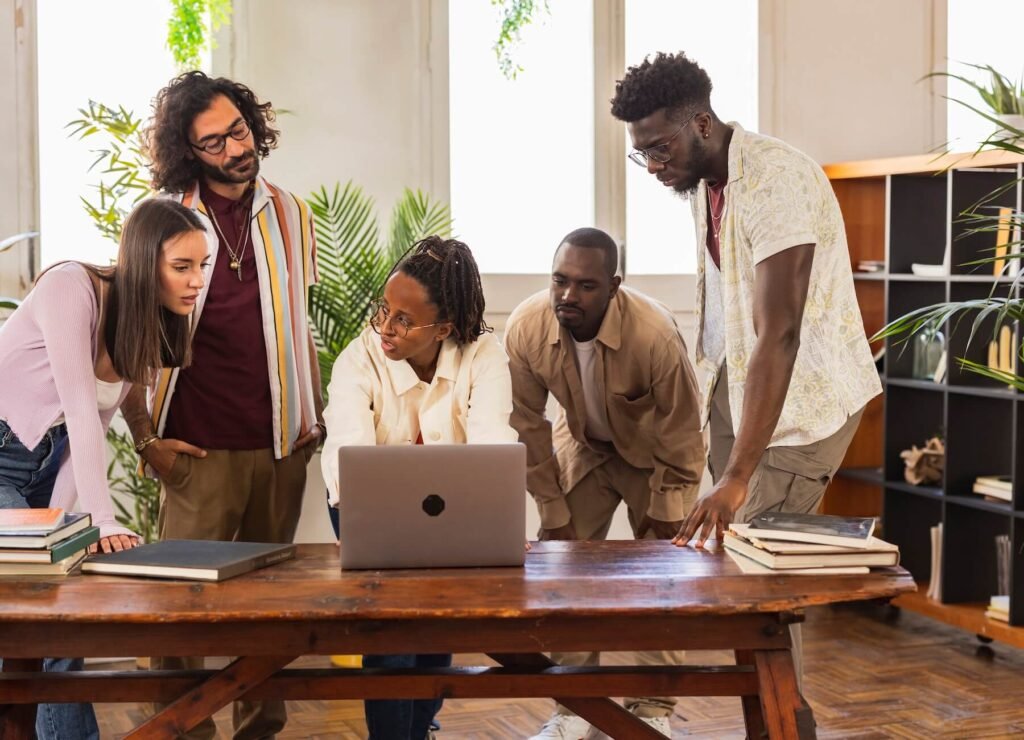 Creative team reviewing work together on a laptop in a plant-filled studio